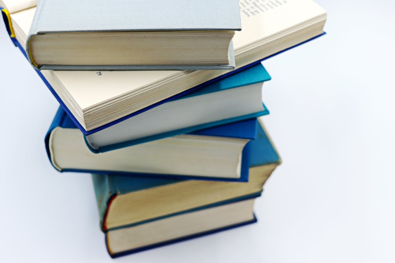 services-02 A pile of books with blue covers on a white background, symbolizing education and knowledge.